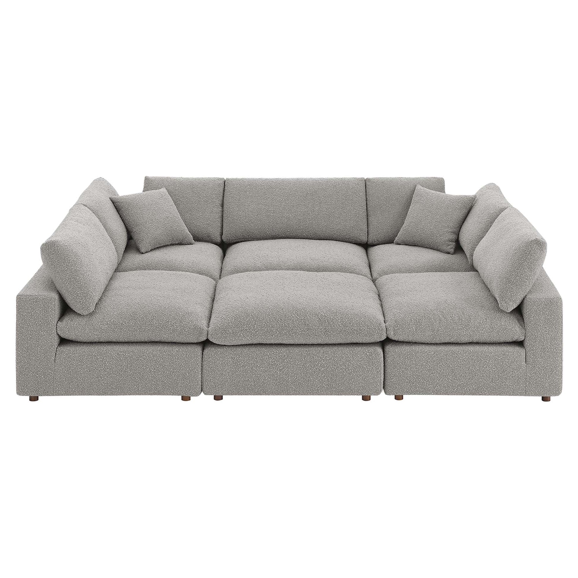 Light gray boucle fabric modular sectional sofa with multiple deep seat cushions and wooden legs.