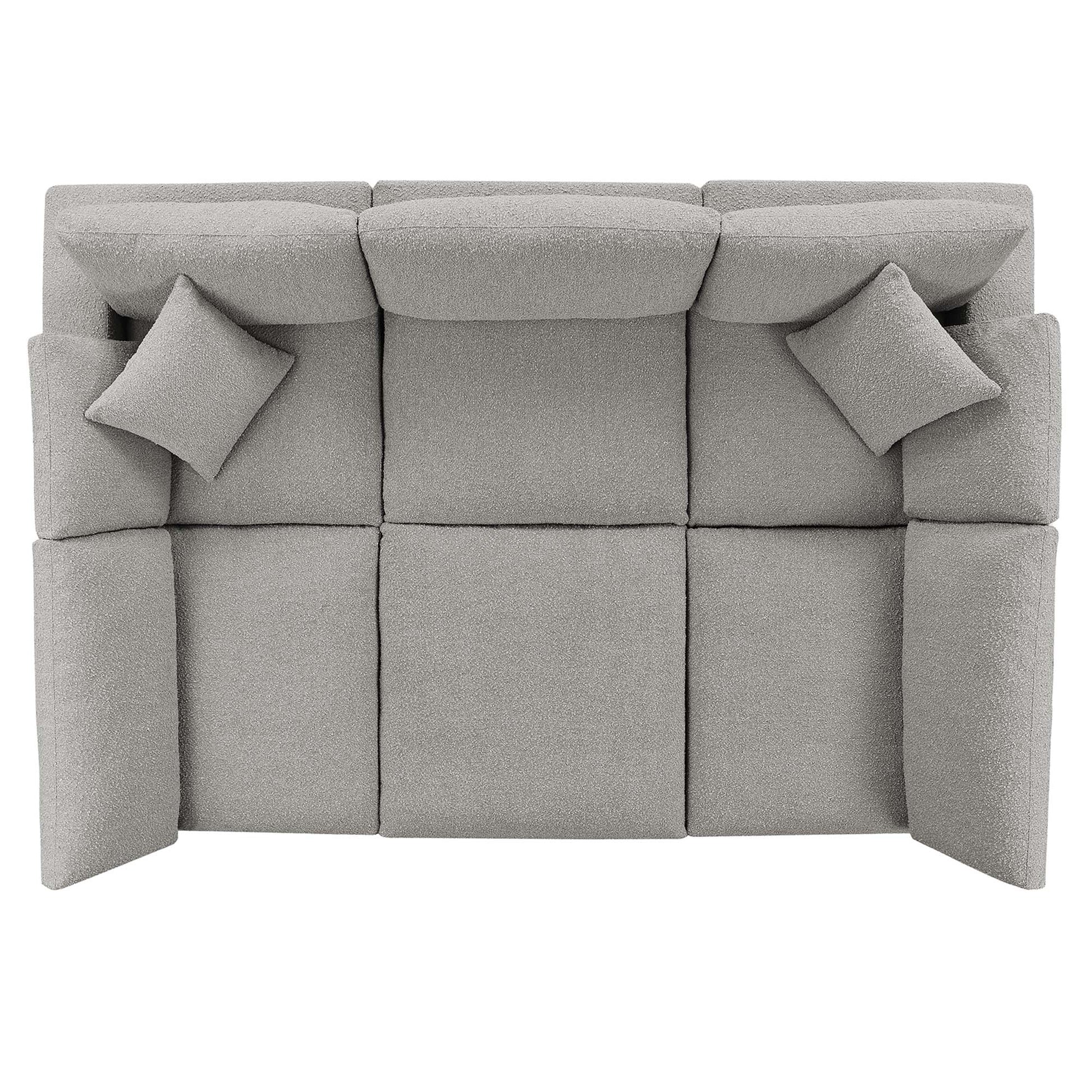 Light gray boucle fabric sectional sofa with two matching square throw pillows.