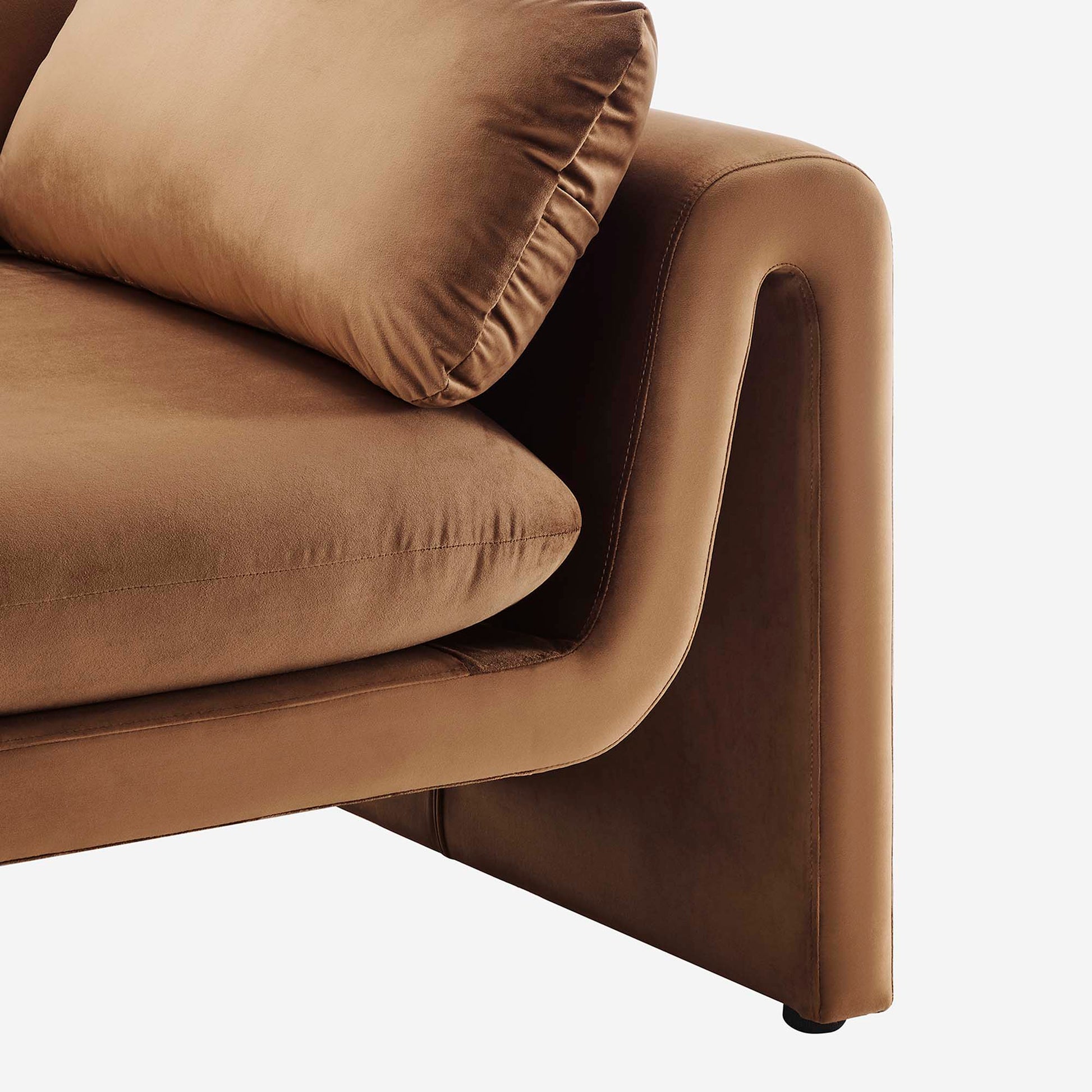 Brown velvet sofa arm with rounded edge and thick cushion, modern mid-century style.