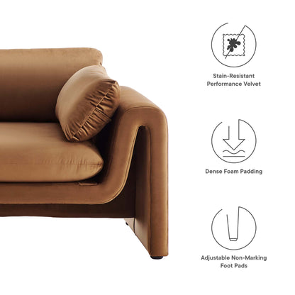 Tan brown velvet sofa with a round bolster cushion; modern low-profile arms, short black feet, foam-padded comfort.