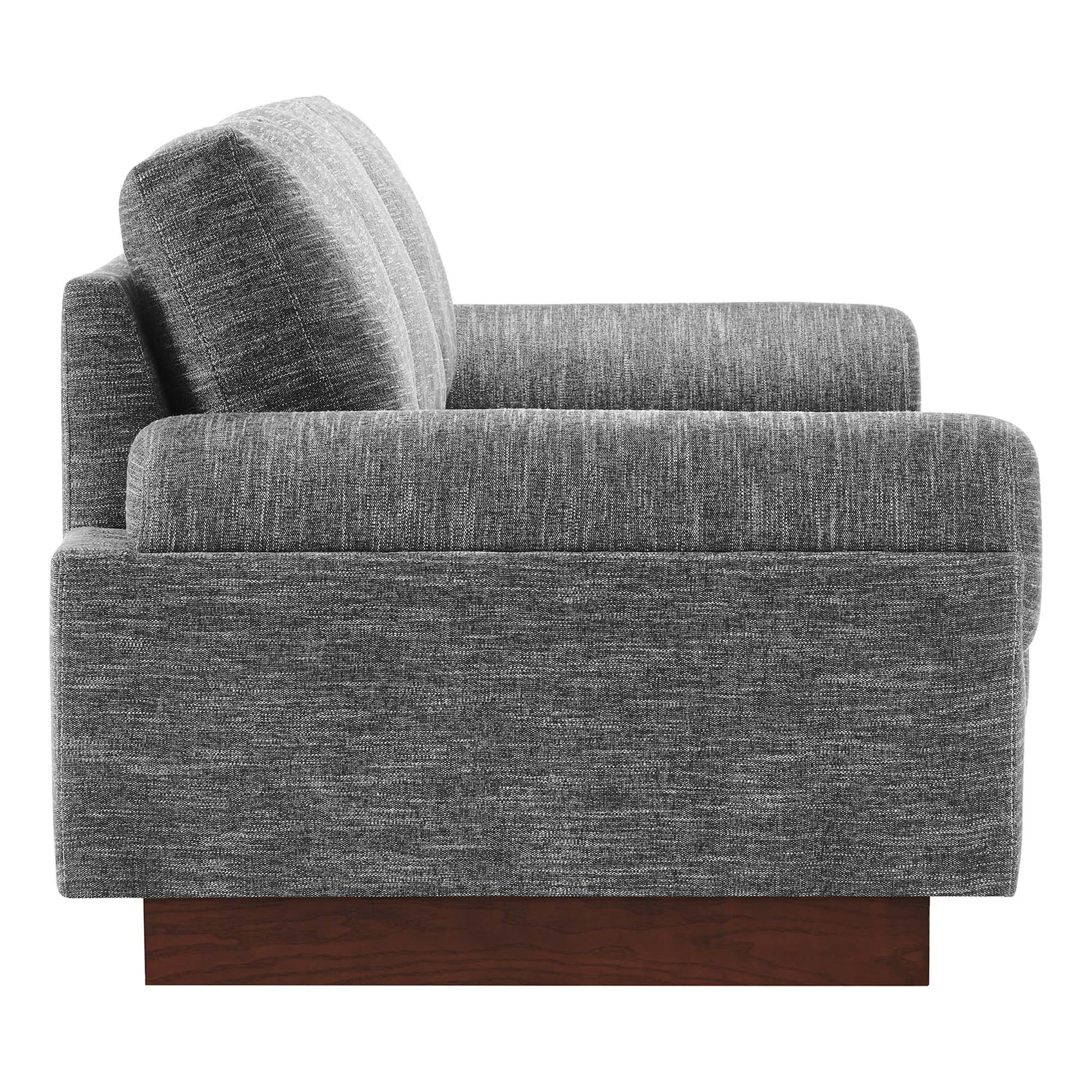 Gray textured fabric sofa with boxy arms, thick cushions, and a dark wood block base.