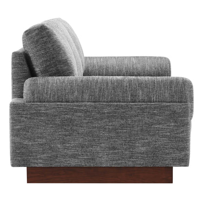 Gray textured fabric sofa with boxy arms, thick cushions, and a dark wood block base.