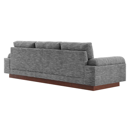 Gray textured fabric sofa with wide boxy arms, back cushions, and a wooden platform base.