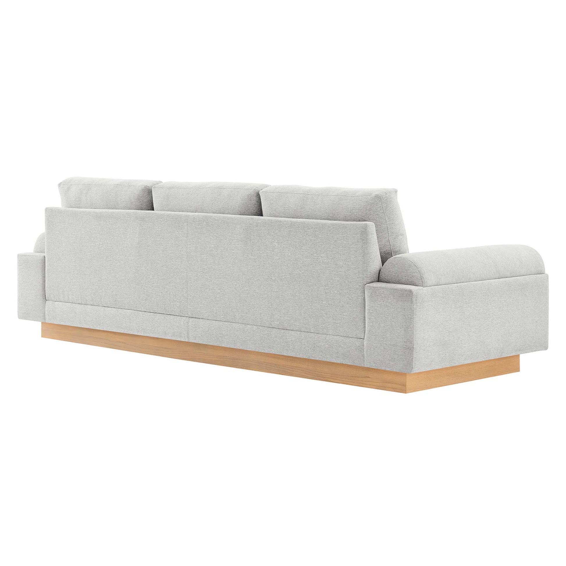 Light gray fabric sofa with wooden plinth base, three-seat cushions, modern block arms, low-profile design.