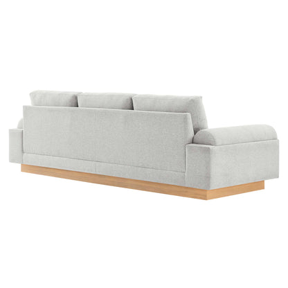 Light gray fabric sofa with wooden plinth base, three-seat cushions, modern block arms, low-profile design.