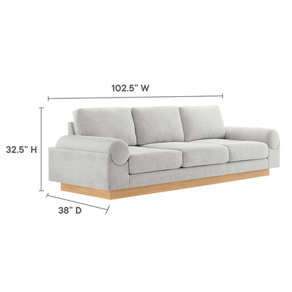 Light gray fabric 3-seat sofa with rolled cylindrical arm on left, natural wood base, three plush cushions.