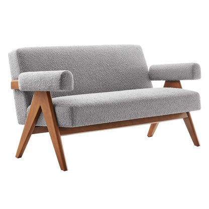 Gray boucle fabric loveseat with wooden angled legs and padded armrests in mid-century style.