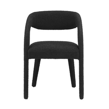 Black boucle upholstered dining chair with curved wraparound back, cushioned seat, and four tapered legs.