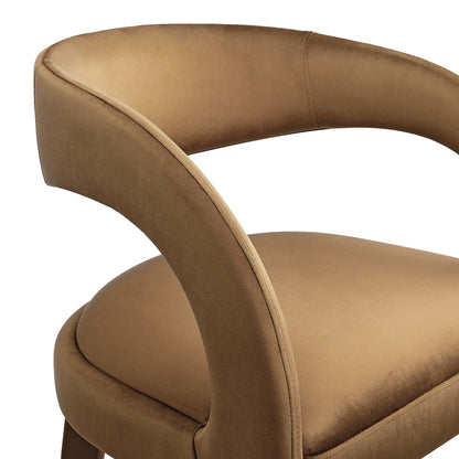 Tan velvet curved bar stool with rounded back and arched armrest, plush seat.