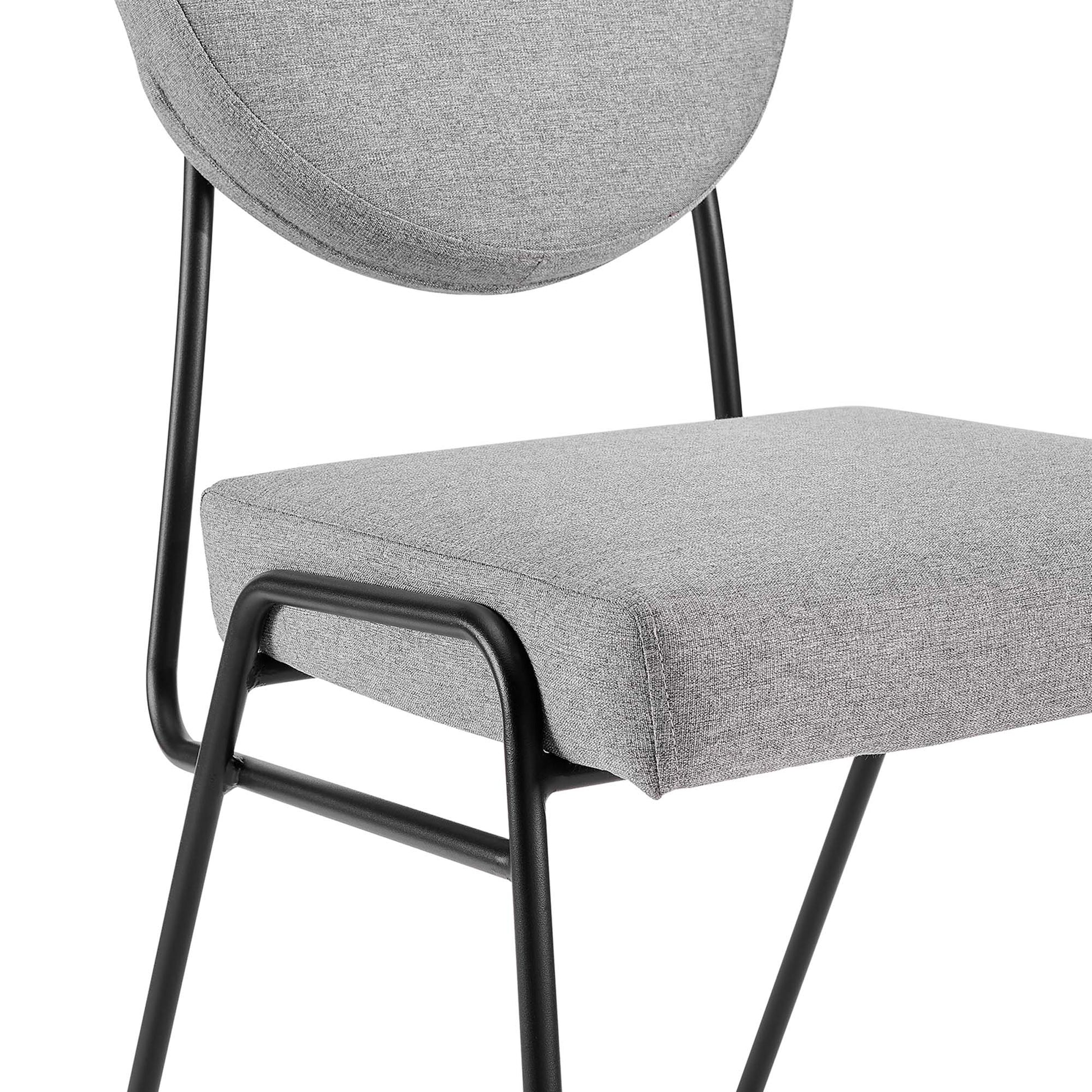 Gray fabric dining chair with circular backrest, rectangular cushioned seat, and black metal frame.