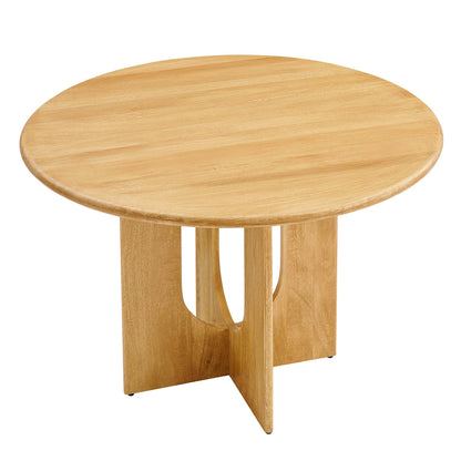 Round oak dining table with a natural light finish; pedestal base with three curved panels forming a sculptural cross