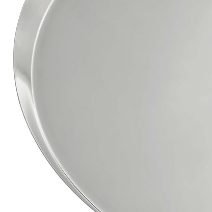 Close-up of a polished metal round side table top with a curved edge and a smooth reflective surface.