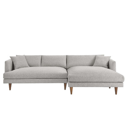 Light gray fabric sectional with right-side chaise, mid-century wooden legs, and two matching throw pillows.