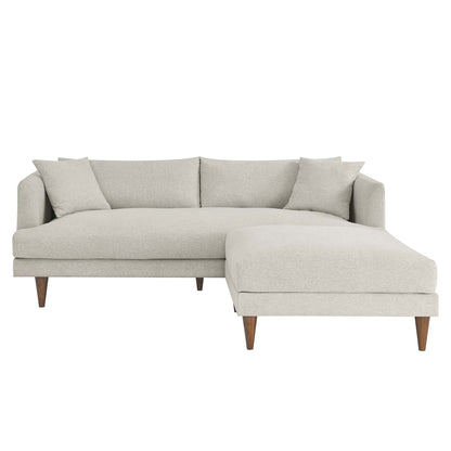 White fabric sofa and ottoman set with down-filled overstuffed cushions, mid-century wooden legs, and matching throw pillows.