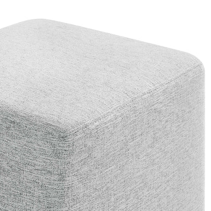 Light-gray textured fabric cube ottoman with rounded edges; modern minimalist footrest or seating.