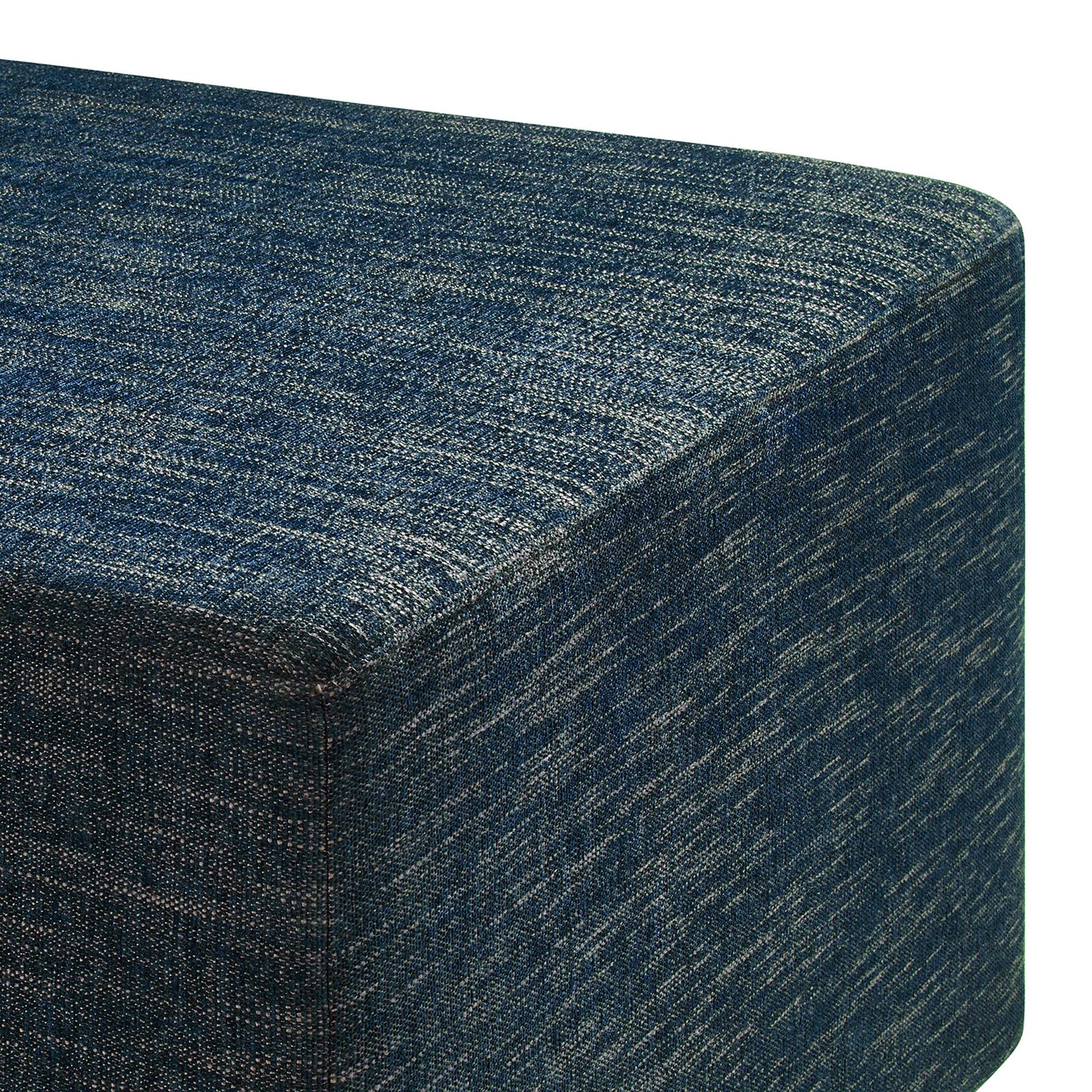 Blue denim-textured fabric cube ottoman with visible seam, versatile footrest & extra seating.