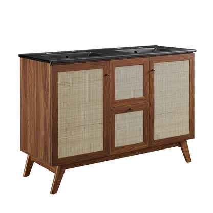 Walnut bathroom vanity with black dual-sink countertop, woven rattan cabinet doors & mid-century angled legs.