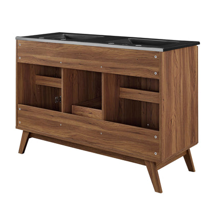 Walnut bathroom vanity with black countertop and double sinks, open cubby shelves, and angled mid-century legs.