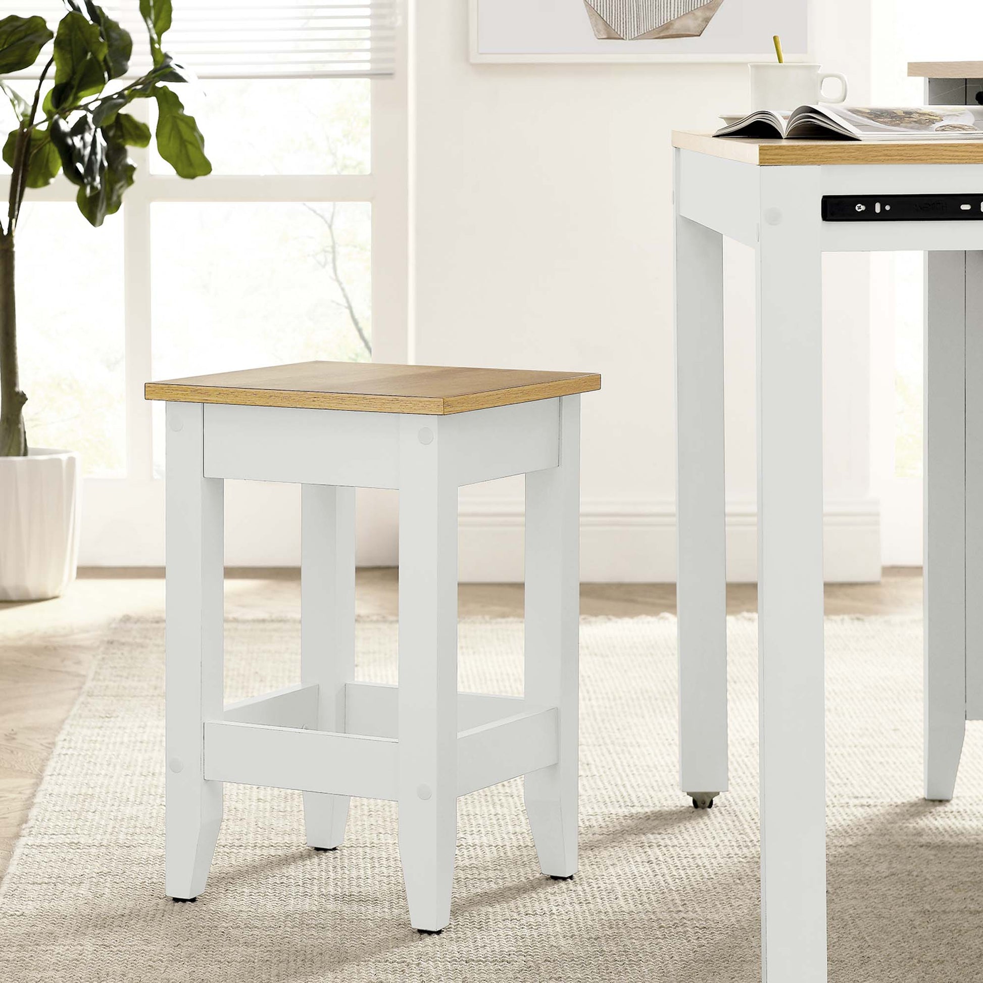White wooden kitchen stool with a natural oak top, square legs & lower crossbars; farmhouse-style.