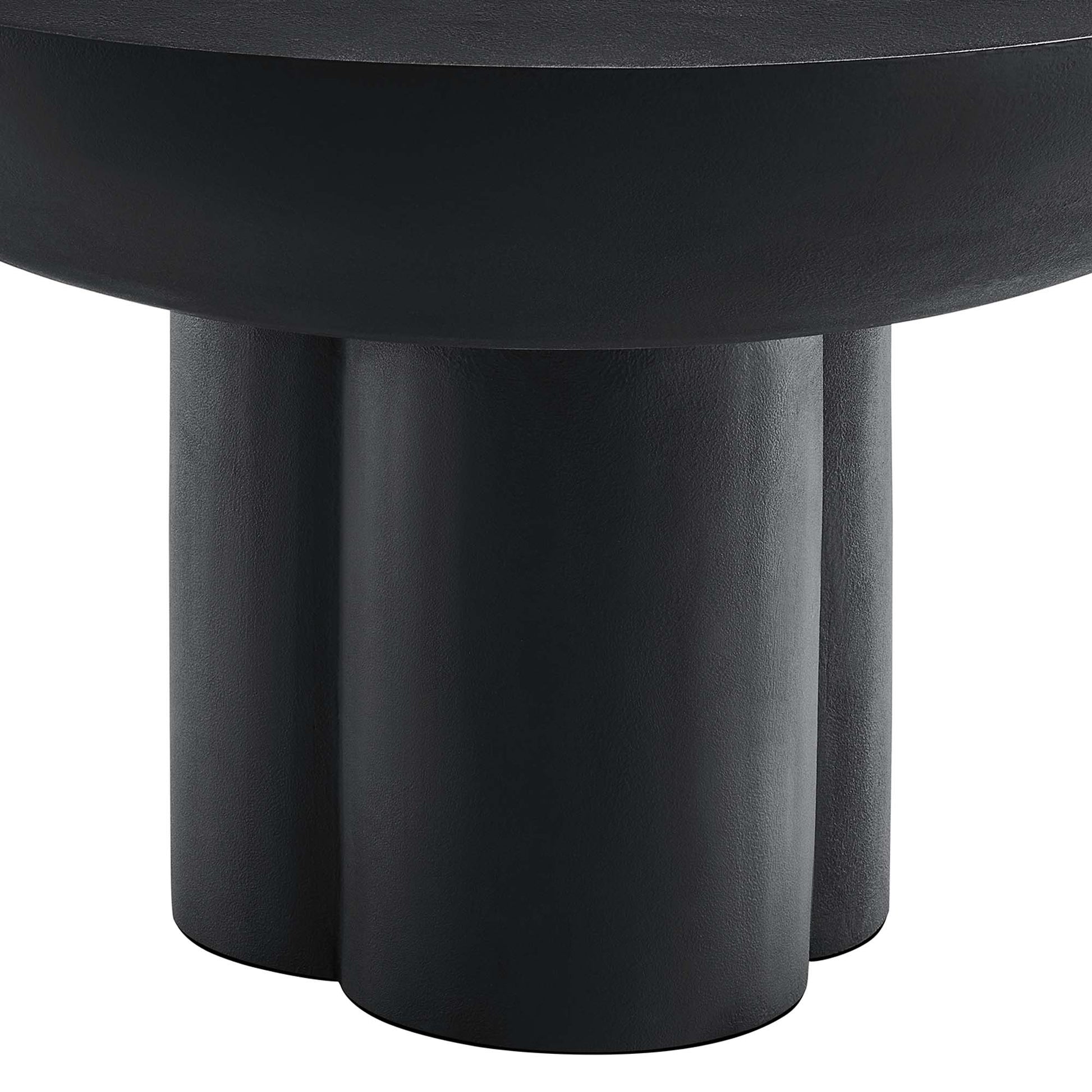 Black round concrete coffee table with three chunky cylindrical legs.