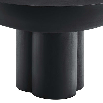 Black round concrete coffee table with three chunky cylindrical legs.