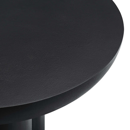 Black round concrete coffee table with a smooth top and visible legs.