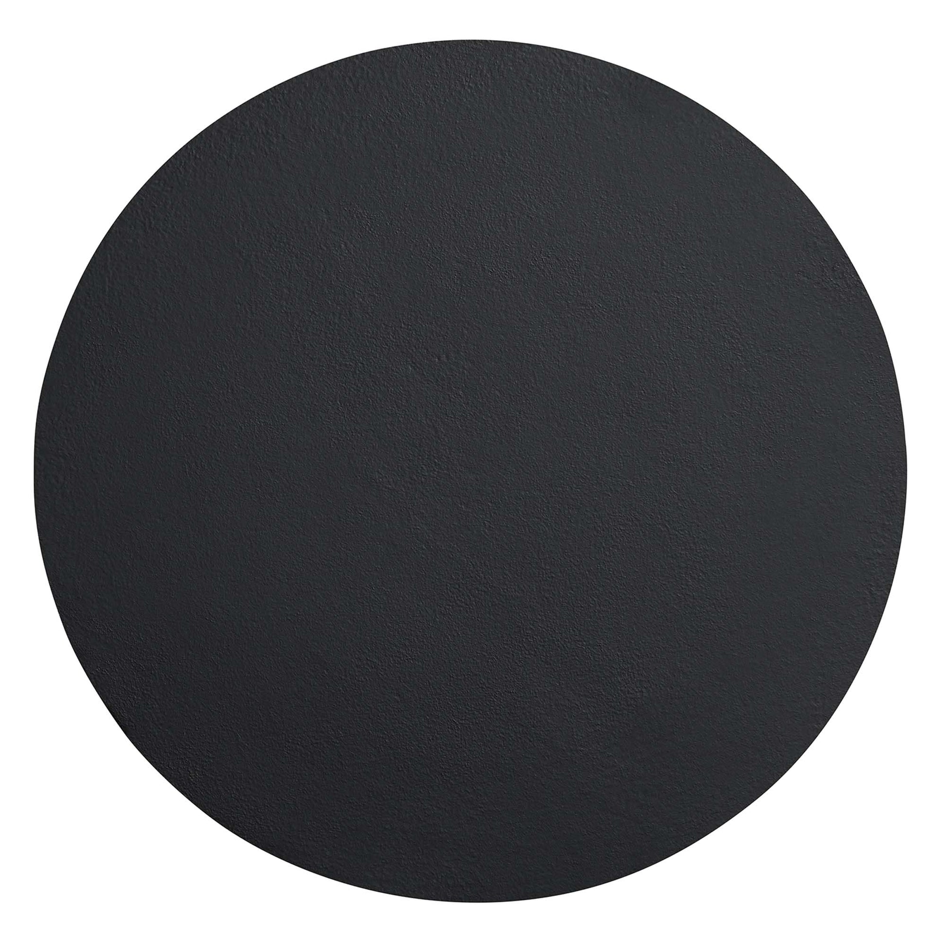 Round black concrete side table with a textured surface