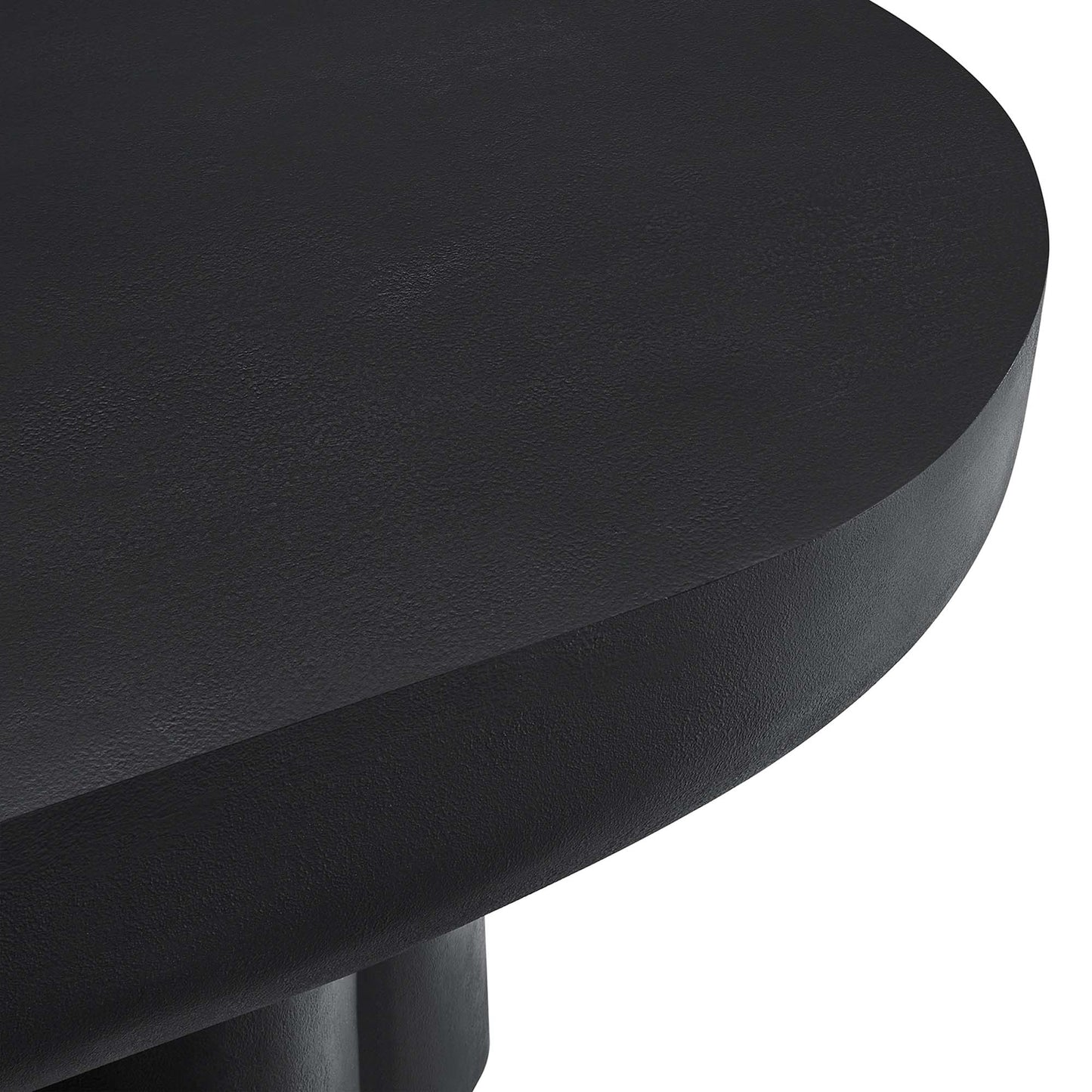 Black oval concrete coffee table with a smooth surface and minimalist design.