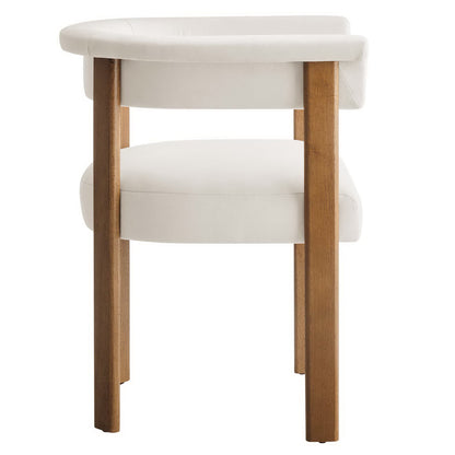 Two white velvet barrel dining chairs with rounded backs and wooden legs.
