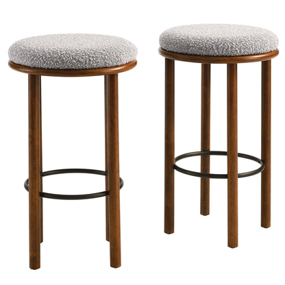 Pair of walnut wood bar stools with round taupe textured fabric seats & black circular footrests.
