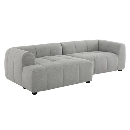 Pewter-gray tufted modular sectional sofa with rounded arms and chaise, low-profile fabric upholstery on short legs.