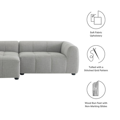 Light gray fabric modular sectional sofa with tufted stitched grid pattern cushions and wood bun feet with non-marking glides.