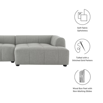 Pewter grey fabric modular sectional sofa with tufted grid cushions and wood bun feet.