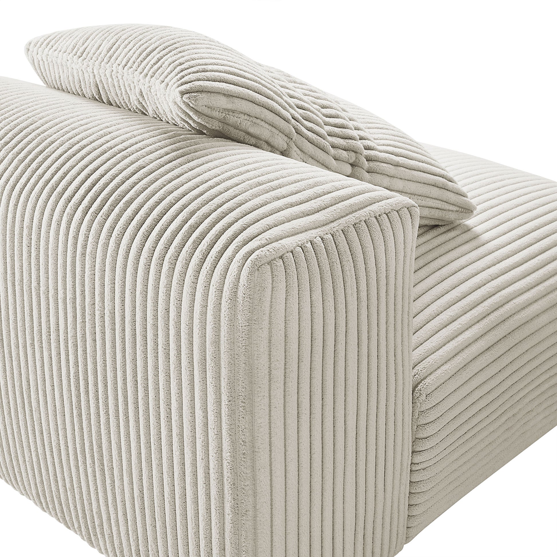 Almond corduroy armless modular chair with vertical ribbed fabric and matching cushion.