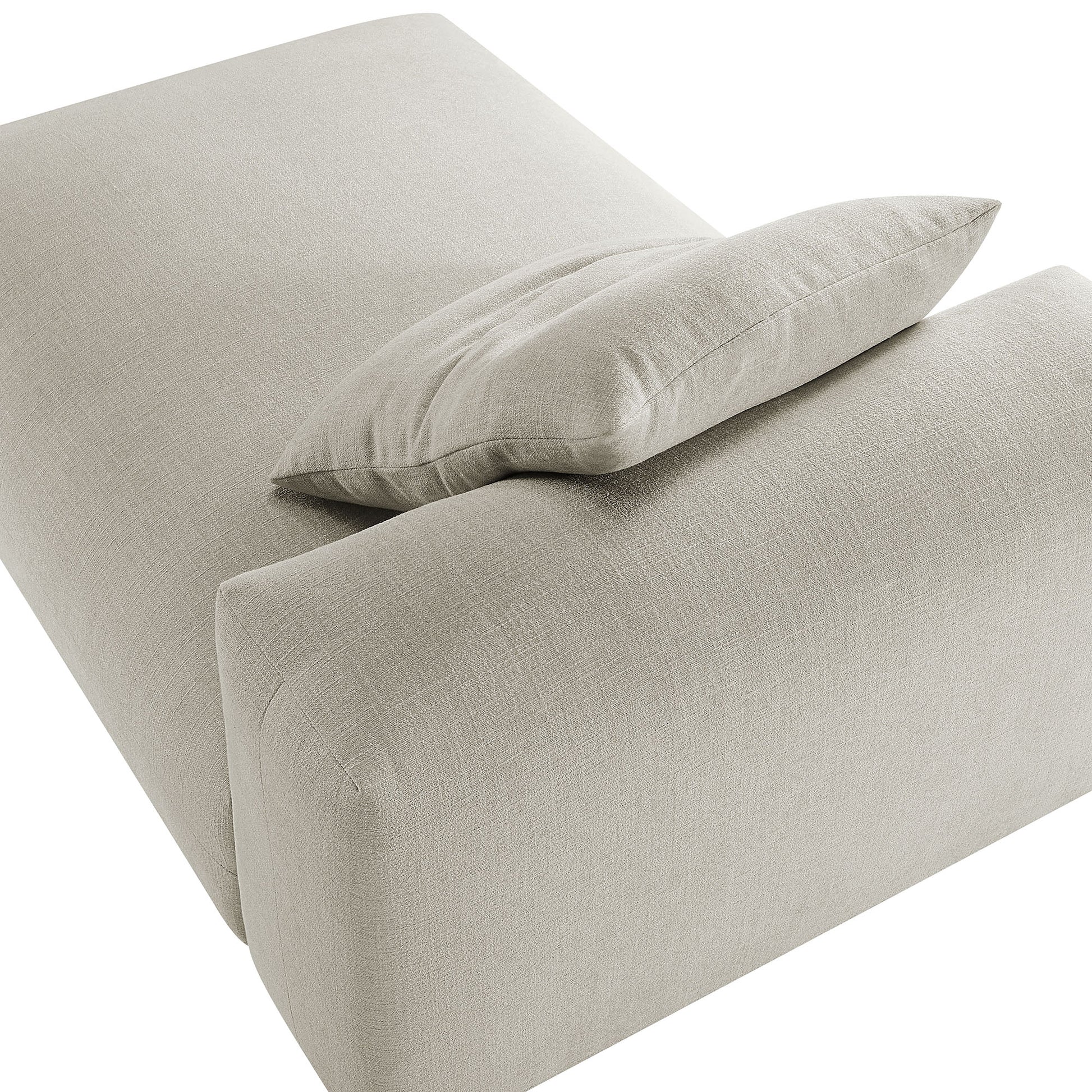 Beige linen fabric modular armless chaise lounge with a low-profile design and a matching throw pillow.