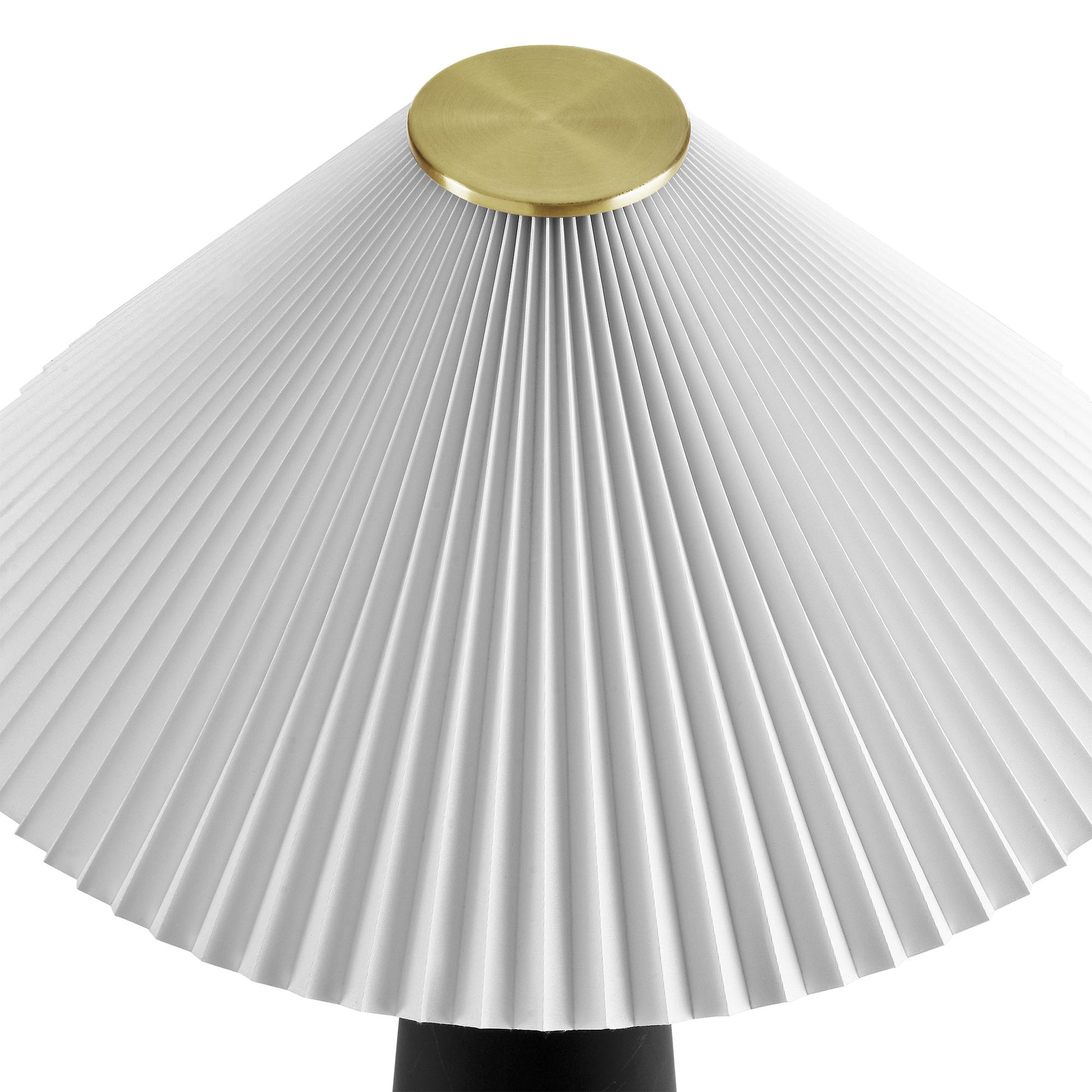 White pleated lampshade with brass cap atop a black table lamp base