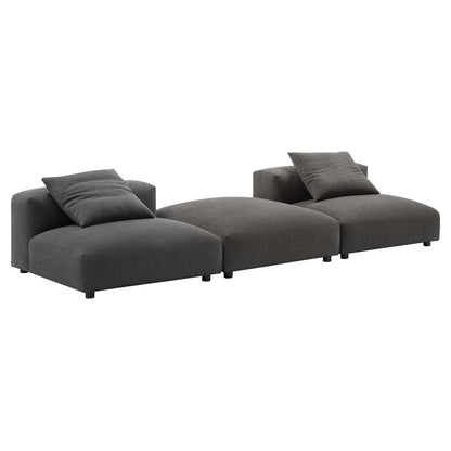 Charcoal gray fabric modular sectional with three connected seats, low-profile arms, short legs, and two matching throw pillows.