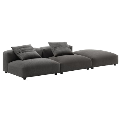 Charcoal gray fabric modular sectional with chaise on the right; low-profile, square cushions, contemporary style.