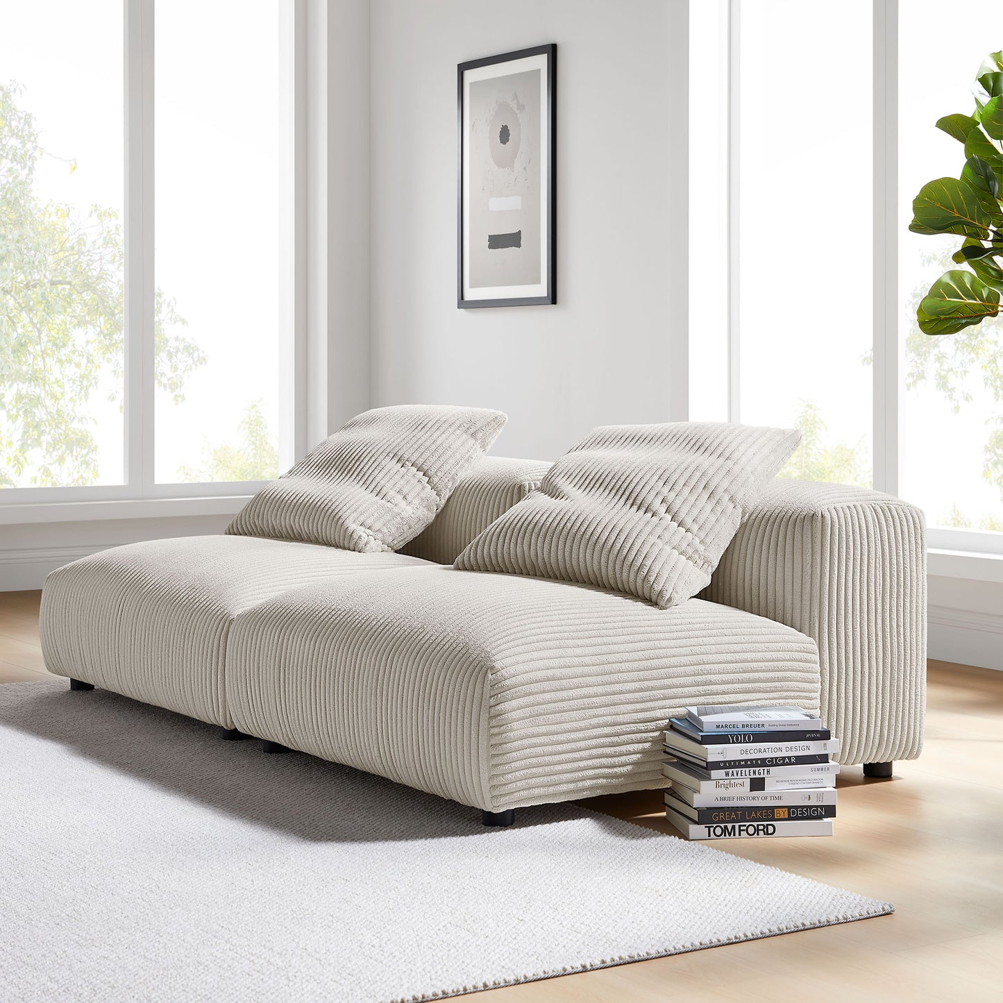 Brown corduroy modular sofa with ribbed upholstery and two pillows in bright living room; books stacked nearby.