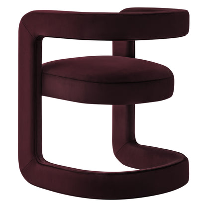 Burgundy velvet dining chair with circular base and integrated armrest loop; sculptural modern design.