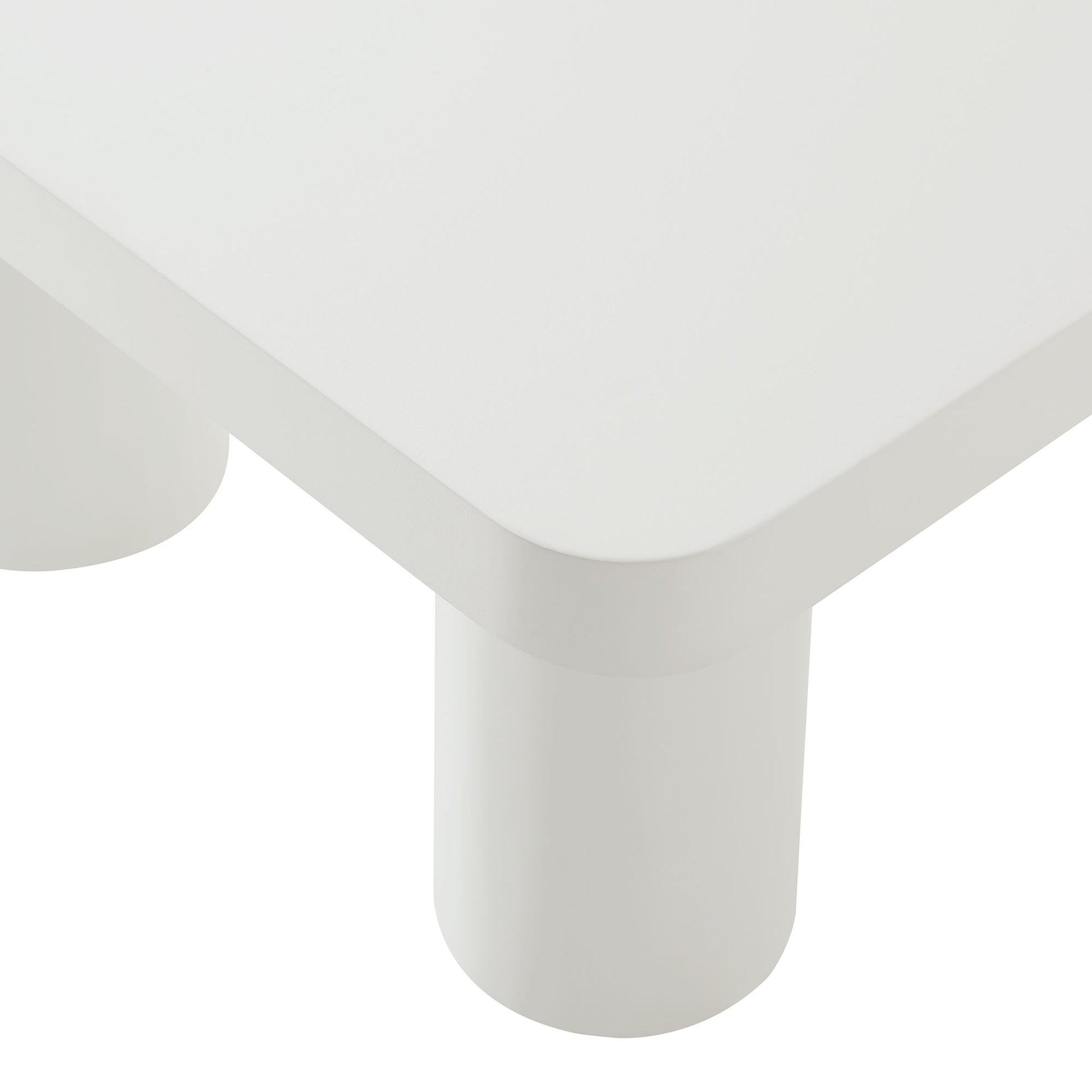 White rectangular coffee table with rounded edges and white cylindrical legs, modern minimalist living room furniture.