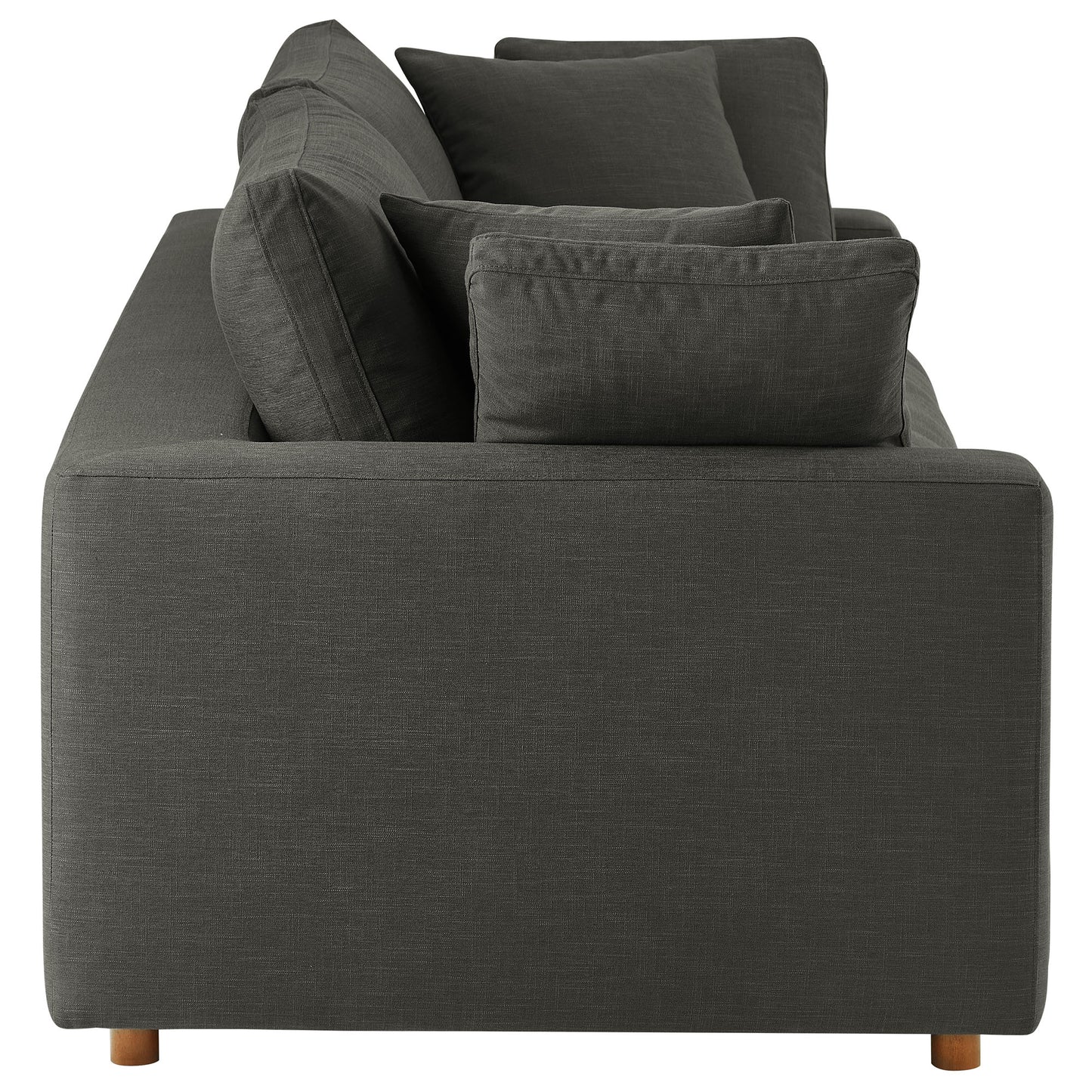 Rear view of a dark gray fabric sofa with square arms and multiple cushions on short wooden legs.