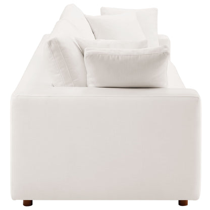 White fabric sleeper sofa with plush back cushions, square arms and short wooden legs in a modern minimalist style.