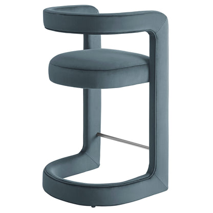 Blue velvet curved counter stool with circular cushion, wraparound back, C-shaped frame and chrome footrest.
