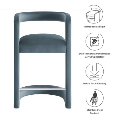 Blue velvet counter stool with a curved frame and stainless steel footrest.
