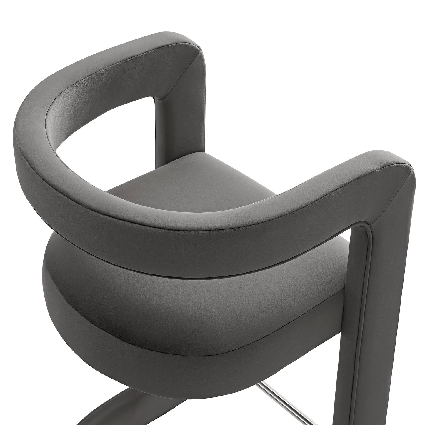 Gray velvet counter stool with curved loop armrests and a rounded seat, modern salon and lounge style.