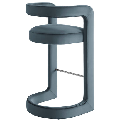 Slate blue velvet barstool with rounded cushioned seat, curved back rail, circular ring base and chrome footrest.