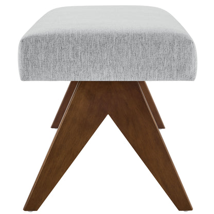 Grey fabric upholstered bench with brown wooden X-frame legs, mid-century modern.