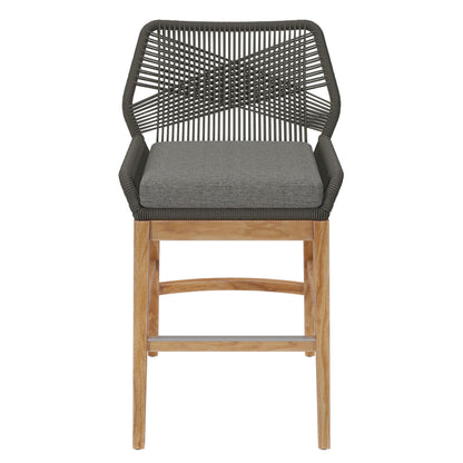 Gray woven rope back counter stool with gray cushioned seat, teak legs & metal footrest.