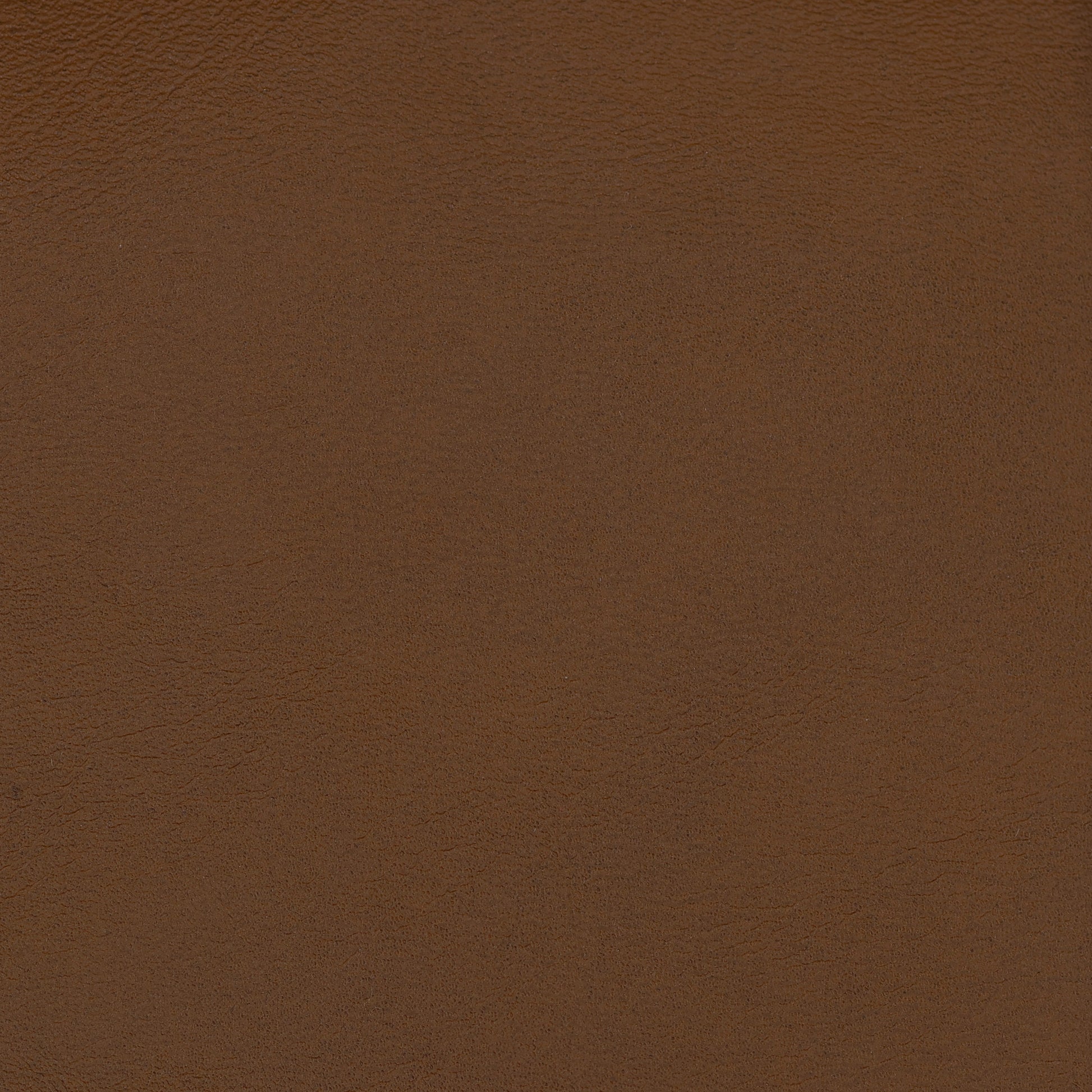 Close-up of brown vegan leather upholstery texture with fine grain & warm chestnut color.